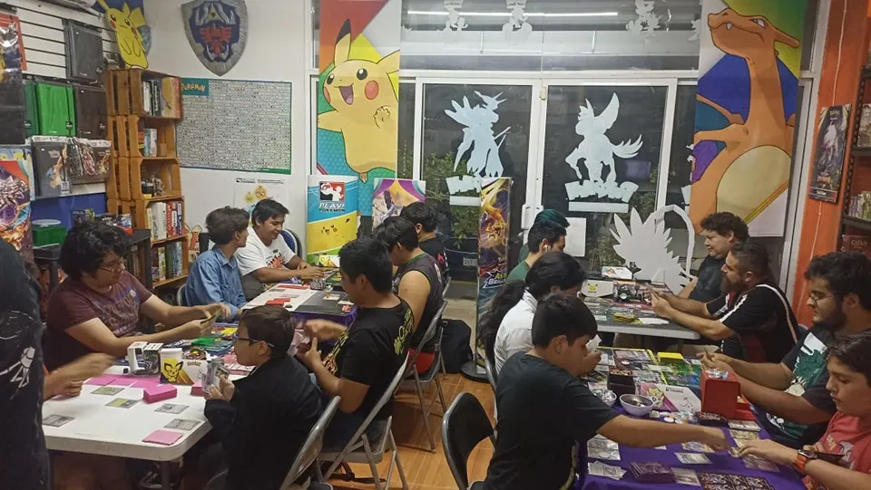 Gente sentada, jugando Pokémon Tcg